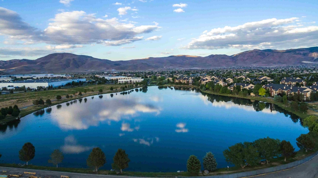 Nestled lakeside in the heart of the South Meadows employment and shopping district, Latitude 39 Apartments in South Reno offer a unique living experience. Enjoy breathtaking lake views in these brand new South Reno apartments while unwinding in our resort pool and spa. Relax by the outdoor fireplace at our 8,400 square foot clubhouse that includes Wi-Fi for residents, 24-hour fitness center, business center, community room and more. Pamper your pup at the indoor dog spa or outdoor dog park and foster imagination at the play area featuring unique play cubes. Incredible interiors make the experience complete with 1, 2 and 3 bedroom apartment homes that include garages (many with direct-access), stainless steel appliances, granite counters, LED lighting, and wood-style plank flooring. Take a tour of the newest South Meadows apartments in Reno– Latitude 39. Apartments in south reno